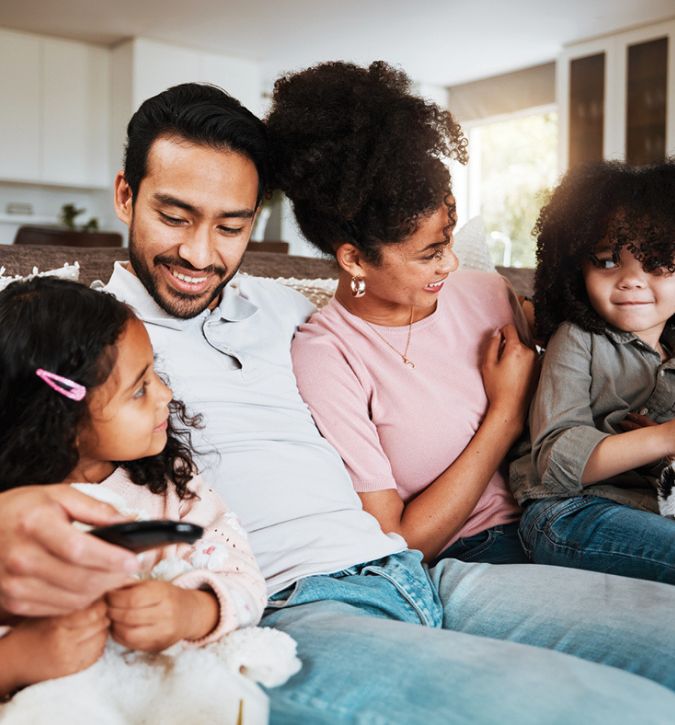 family sitting on couch watching TV