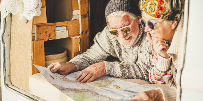 Senior couple wearing sunglasses and reading a map